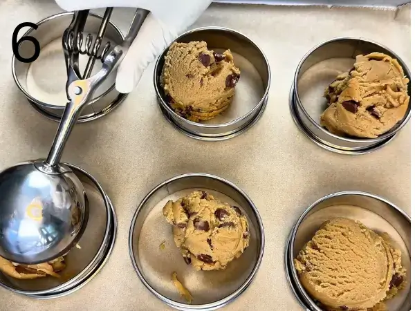 Scooping stuffed chocolate chip cookies dough onto baking tray