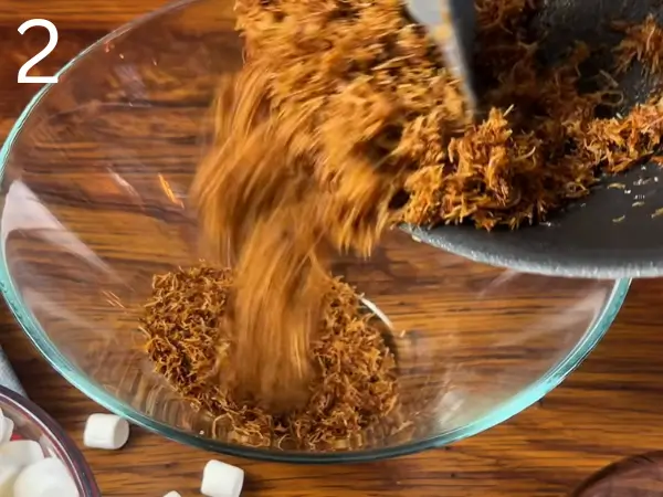 adding kataifi strands and separating them gently with a spatula
