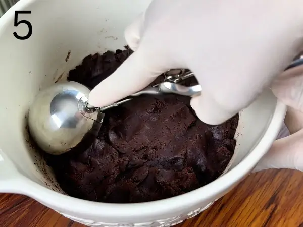 Shaping chocolate cookie dough into balls before baking
