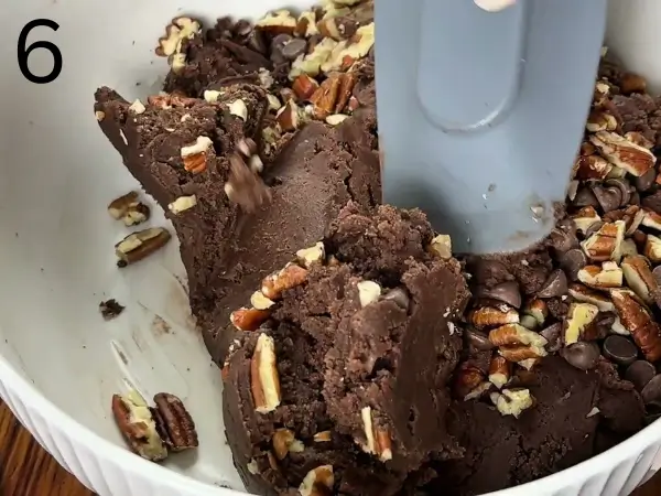 adding chocolate chips and pecans to cookie dough