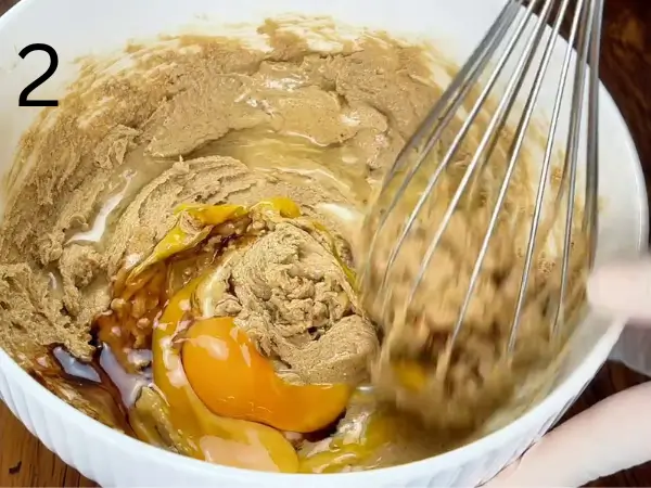 Adding eggs and vanilla to cookie batter