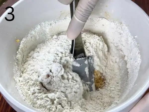 mixing dry ingredients into soft cookie dough