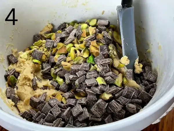 folding chocolate chunks and pistachios into dough