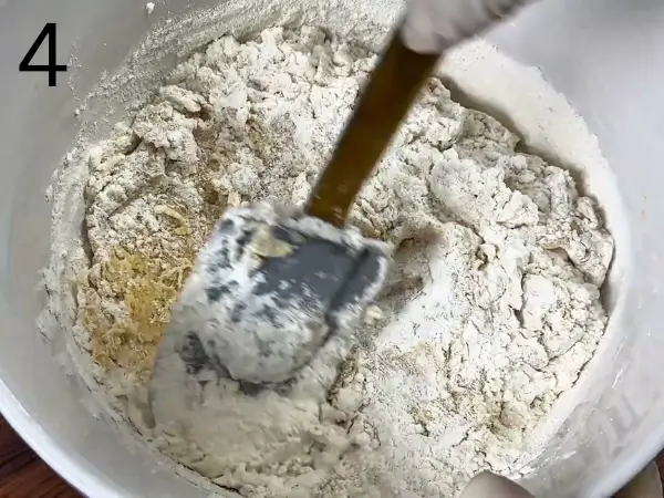 Adding dry ingredients to cinnamon roll cookies dough bowl