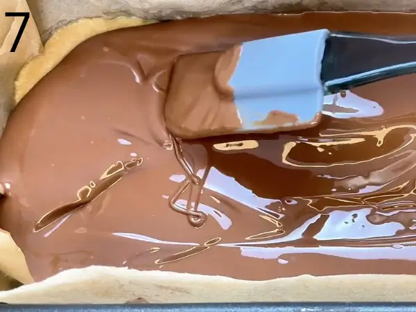 Pouring melted chocolate over No-Bake Cookie Bars
