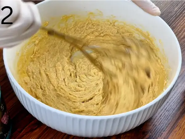 Adding eggs and vanilla to soft stuffed cookie dough mixture