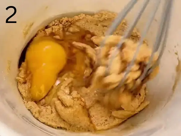 Adding egg, vanilla extract, and dissolved coffee to the cookie mixture.