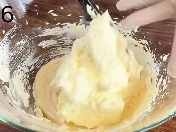 Mixing mascarpone cheese and whipped cream to make a smooth tiramisu filling.