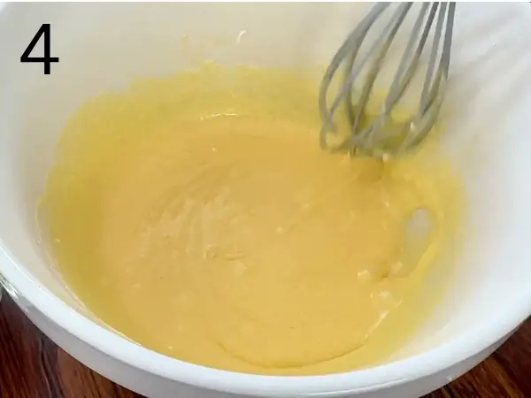 Creamy almond filling being prepared by mixing butter, sugar, egg, almond extract, and ground almonds.