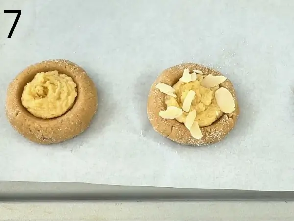 Almond Croissant Cookies filled with creamy almond filling and topped with sliced almonds before baking.